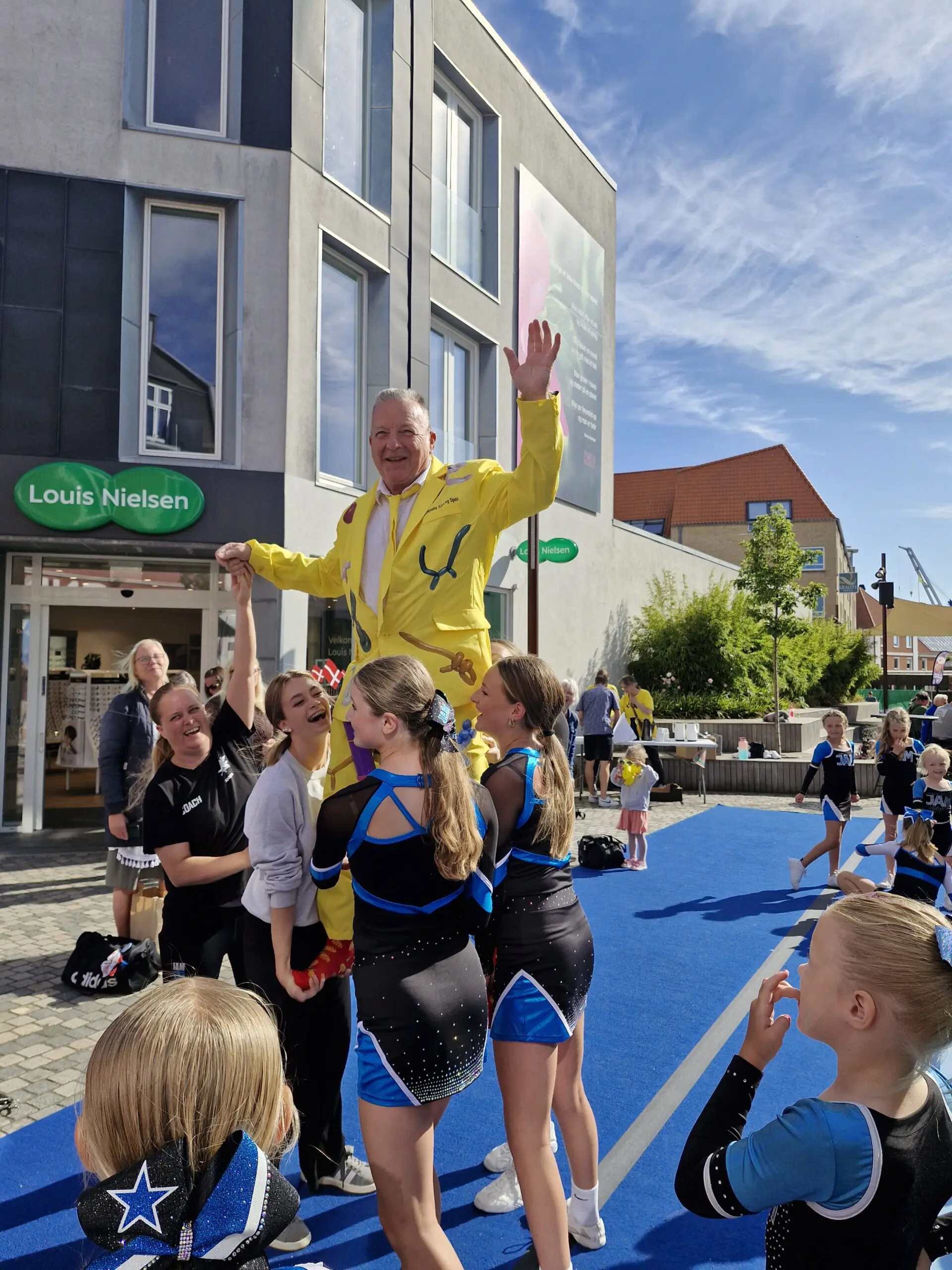 Ballonkunstneren Jakob i gul jakke til et arrangement foran Louis Nielsen