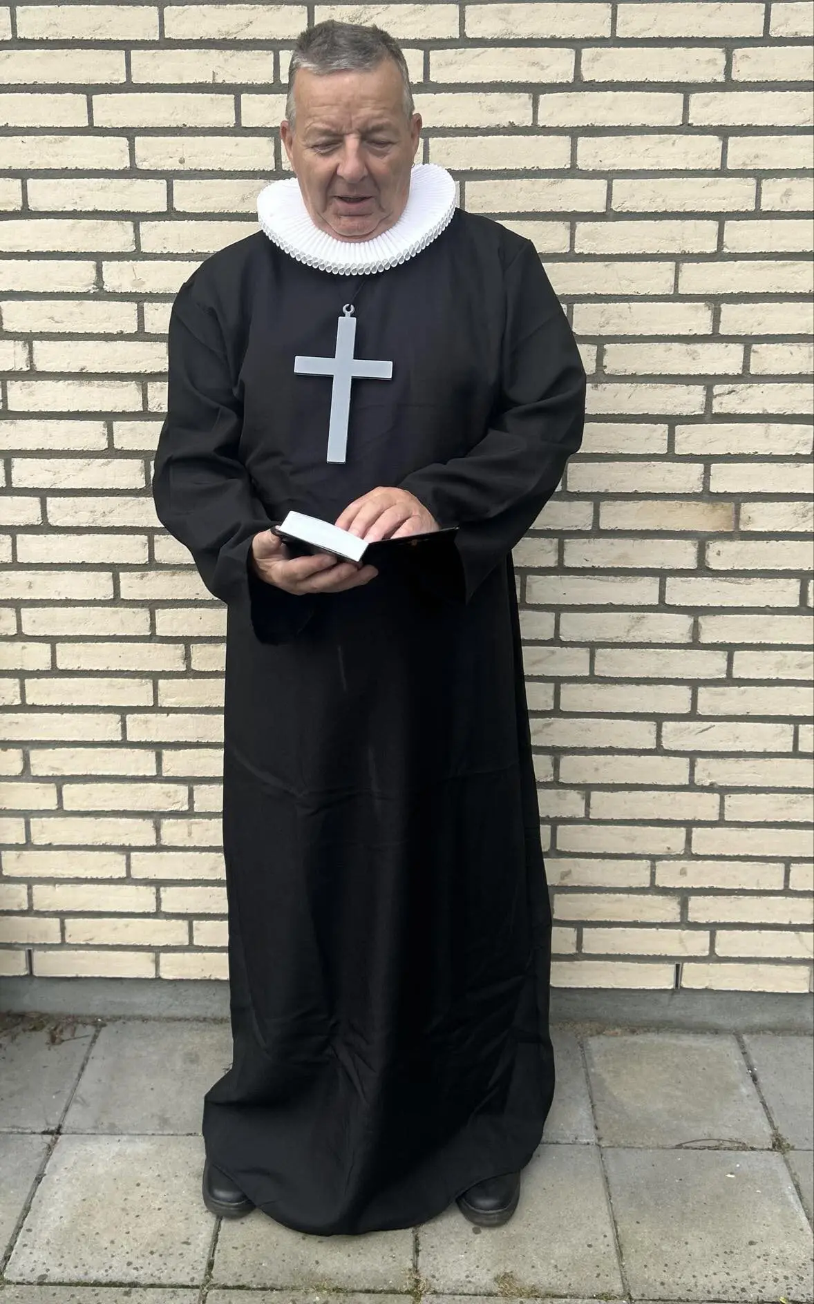 Pastor Jakobsen i præstekjole med krave og bibel